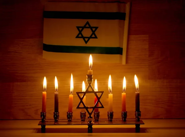 Hanukkah a zsidó ünnep. Égő Hanuka gyertyatartó, gyertyával. Chanukiah Menorah. Izrael zászlaja — Stock Fotó