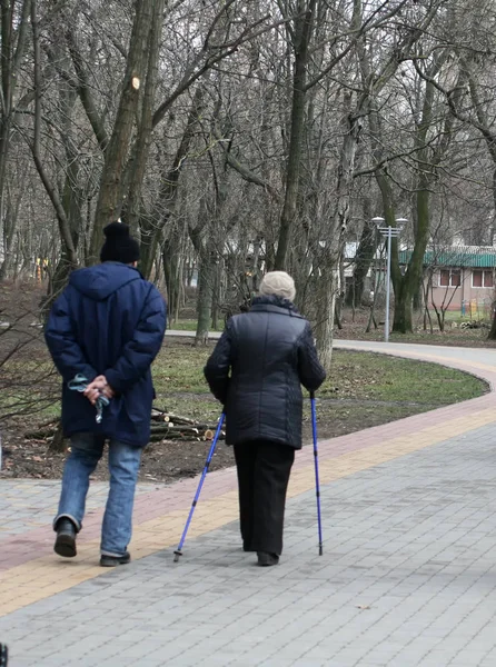 Starý starší muž a žena chodí s holí — Stock fotografie