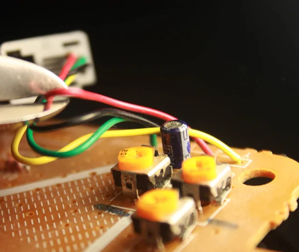 Electrical board with electronic components. High-tech printed circuit board. Cutting the electric wire with wire cutters