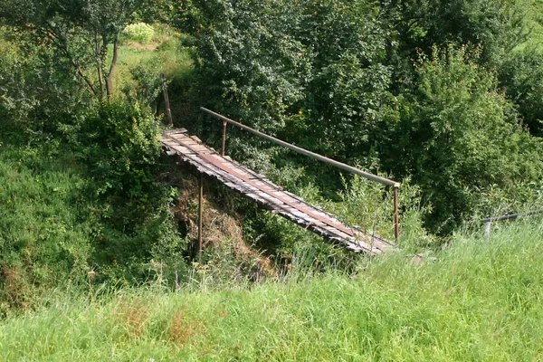 Old bridge over the ravine. Wooden bridge over the river.