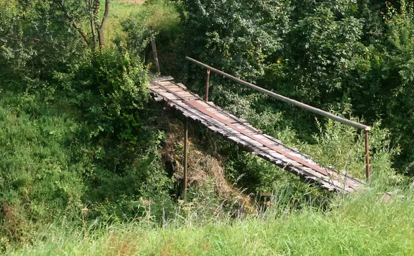 Old bridge over the ravine. Wooden bridge over the river.