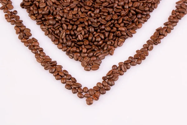 Part of the heart made of roasted coffee beans. On a light background.