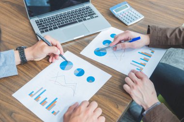 İş adamları toplantı sırasında mali raporları tartışıyor