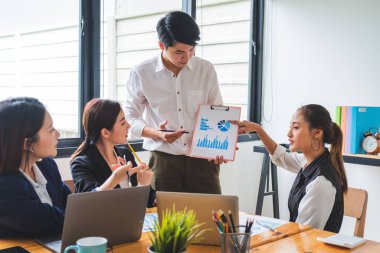 Genç Asyalı bayan girişimci iş hayatında takıma günlük sunum yapıyor.