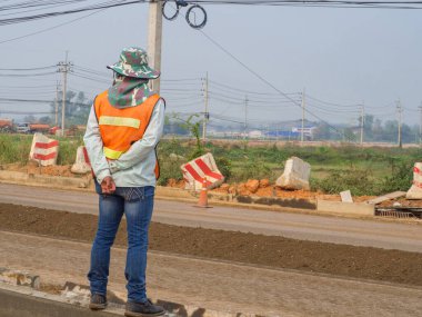 Yol yapımını kontrol etmek için ayakta duran genç adamın arka görüntüsü