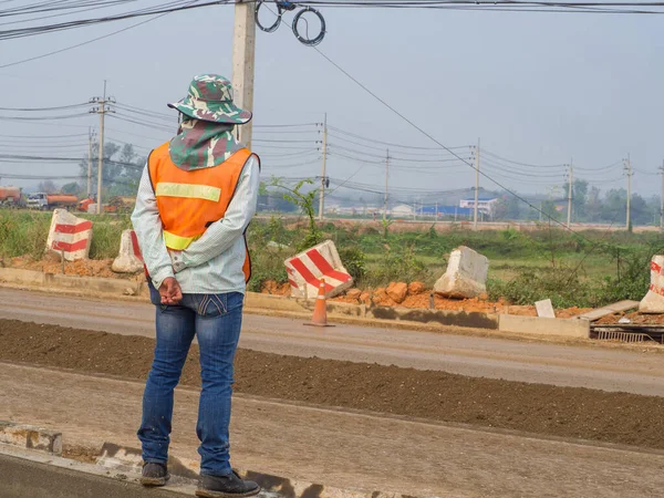 Back view of young man\'s worker standing to control the road construction