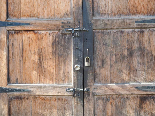 Full frame photo of old wooden door and locked ke