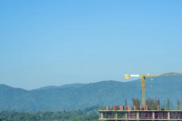 Construction site with crane on sky and cloudy background. Big machinery construction crane tool of building industry for heavy lifting. Business engineering equipment modern. Industry concept