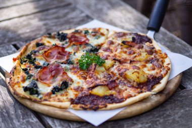 Ahşap tabakta servis edilen lezzetli ev yapımı pizza.
