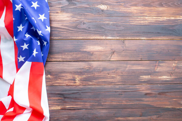 Close-up of the American flag is placed on the left side with copy space on a wooden table background. 4th of July. Celebrate American National Day. Labor Day. Independence Day. Memorial Day.