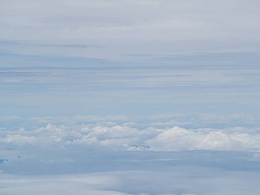 Uçak penceresinden görülen bulutlu hava manzarası. Metin için boşluk.