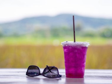 Güneş gözlüğü, akıllı telefon ve şifalı bitki suyu ya da beyaz ahşap masa üzerinde beyaz ahşap bezelye suyu. Metin için boşluk