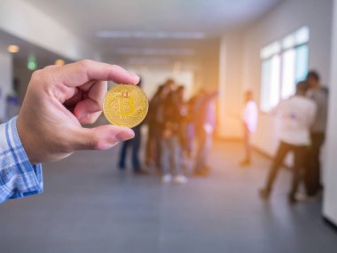 Ofis geçmişi olan bir bitcoin 'i tutan adamın yakın çekimi. Metin için boşluk