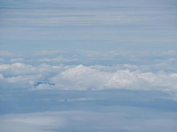Aerial view of cloudscape seen through airplane window. Space for text