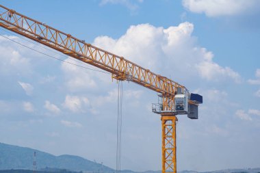 Mavi gökyüzü arka planında vinç olan bir inşaat alanı. Ağır kaldırma endüstrisi için büyük bir vinç inşaat aracı. İş mühendisliği ekipmanları modern. Endüstri kavramı