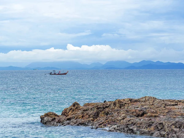Parlak mavi deniz yüzeyi ve yüzen uzun kuyruk teknesi olan deniz manzarası. Tayland 'ın Phuket kentindeki Maithon Adası' ndan (Koh Mai Thon) deniz manzarası
