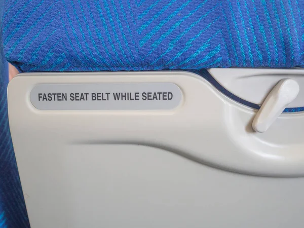 シートベルトを固定しながら 飛行機の単語の記号 フルフレーム写真 — ストック写真