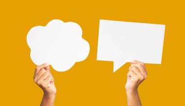 Stüdyoda turuncu bir arka planda beyaz bir konuşma balonu tutan ellerin yakın çekimi. Yakın plan fotoğraf. Metin için boşluk