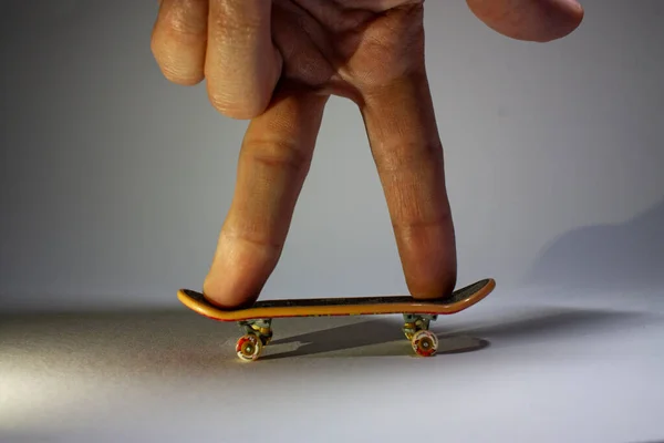 Горизонтальная Фотография Двух Пальцев Управляющих Катающихся Уменьшенном Скейтборде — стоковое фото
