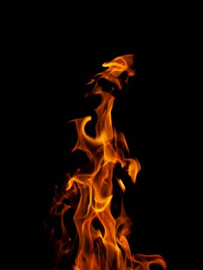 İzole edilmiş parlak turuncu bir alevin dikey görüntüsü. Siyah arka planda sayısız dil var. 