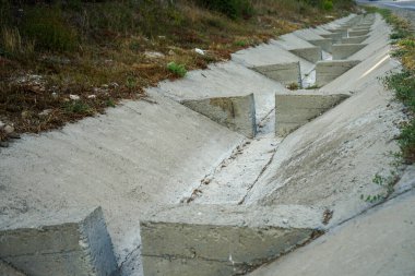 Bir dağ yolu boyunca sıradışı yağış var. Atlayıcılarla birlikte yamaçtan aşağı akan suyun hızını azaltmak için.