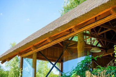 Sazdan çatılı bir restoran terası. Manzarası harika. Açık güneşli yaz günü.