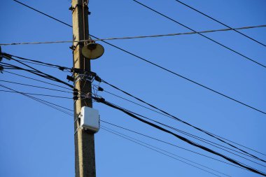 Elektrik direkleri üzerindeki yüksek teknoloji kablolu internet ekipmanları modası geçmiş, bozuk sokak aydınlatma tesisatlarıyla çevrelenmiş durumda.