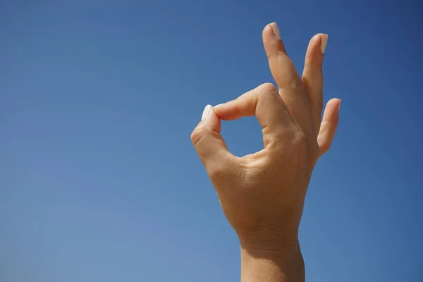 Красивая Женская Рука Демонстрирует Символ Хорошо Фоне Ясного Голубого Неба — стоковое фото
