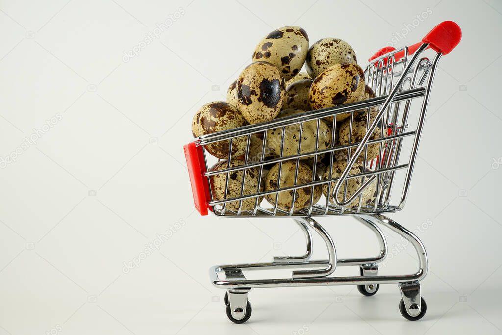 beautiful calibrated quail egg in miniature size supermarket trolley close-up on white background