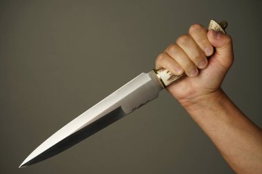 Adamın elinde iki ucu keskin bir bıçak ve bir de kemik sapı var.