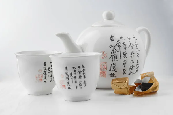 stock image Chinese tea set on a white background with black pu-erh on the side