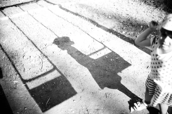 Bir kızın gölgesi ve parkta bir salıncak.