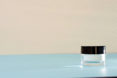 Siyah kapaklı küçük beyaz bir kavanoz.