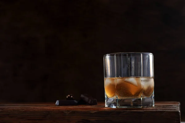 얼음이든 위스키 차가운 알코올 음료는 어두운 초컬릿 조각을 유리잔에 알코올 — 스톡 사진