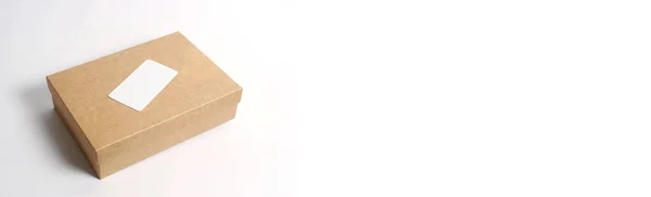 Cardboard craft box with cover on white background top view. The concept of delivery, mail, destinations, the quarantine period is relevant. Copy space. Delivery business card with place for text.