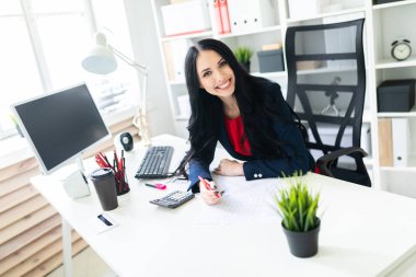 Hesap makinesi ve Office belgeleri ile masada çalışan güzel bir genç kız