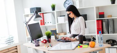 Genç bir kız bir tablo duruyor ve klavyede yazdırır. Kız bir manyetik kurulu ve işaretleri olmadan.