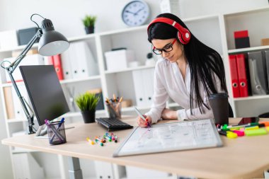 Genç bir kız kulaklık tablo anlamına gelir ve bir işaretleyici manyetik bir tahtaya çizer.