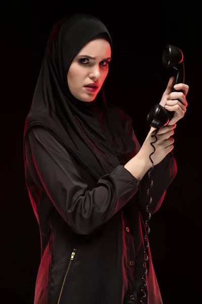 Portrait de belle jeune femme musulmane effrayée et sérieuse portant le hijab noir appelant à l'aide sur fond noir — Photo