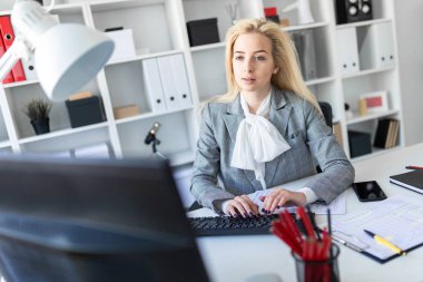 Genç kız ofiste bilgisayar ve belgeler ile çalışma.