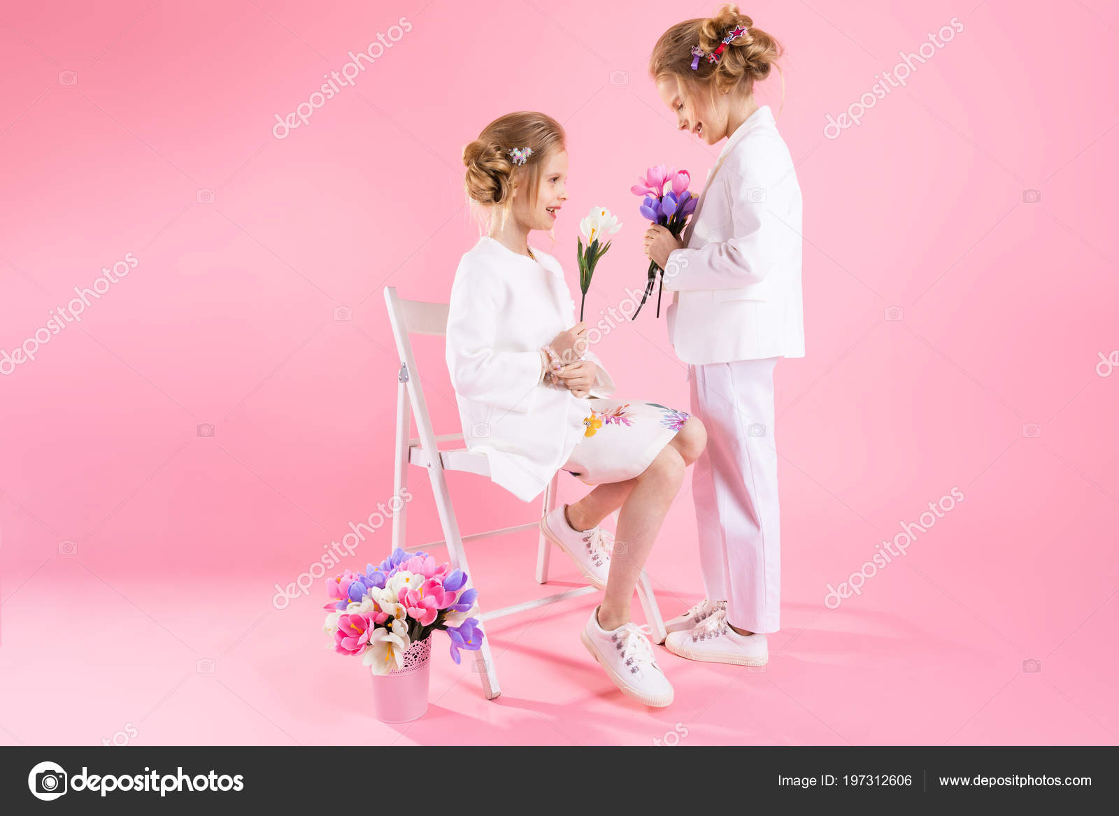 Twins Girls In Light Clothes With Bouquets Of Flowers Posing