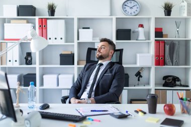 Masada ofiste adam sandalyenin arkasına doğru eğik ve pencereden dışarı baktım.