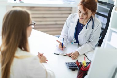 Kızıl saçlı Genç kız beyaz önlük ve boynunda steteskop ile. Saç bir topuz toplanır. alan derinliği ile fotoğraf