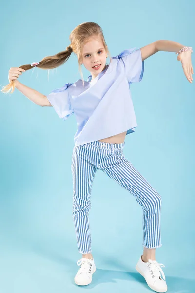 Full-length portrait of a beautiful girl in blue clothes on a blue background. — Stock Photo, Image