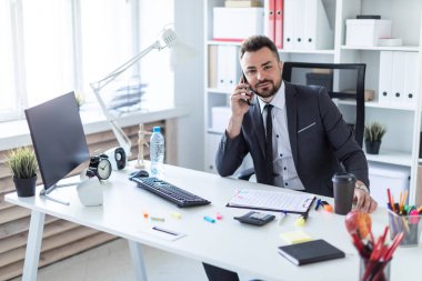 Bir adam ofiste masa başında oturan, telefonda konuşurken ve düz arıyorsunuz.