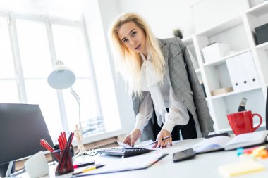 Genç bir kız ofiste standları, ellerini masanın koy.