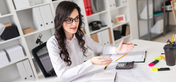 Mooi meisje zit aan de tafel in het kantoor en onderhandelingen houdt. — Stockfoto