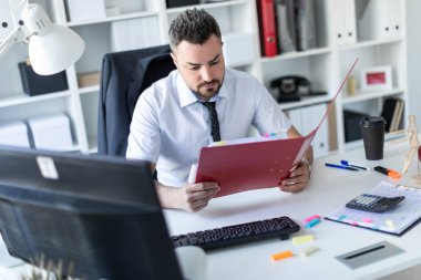 Bir adam ofiste masada oturan ve belgeleriyle çalışma.