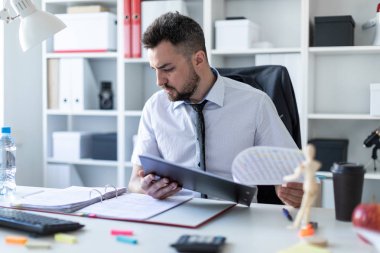 Bir adam oturuyor ve verilirse aracılığıyla belgeleri.