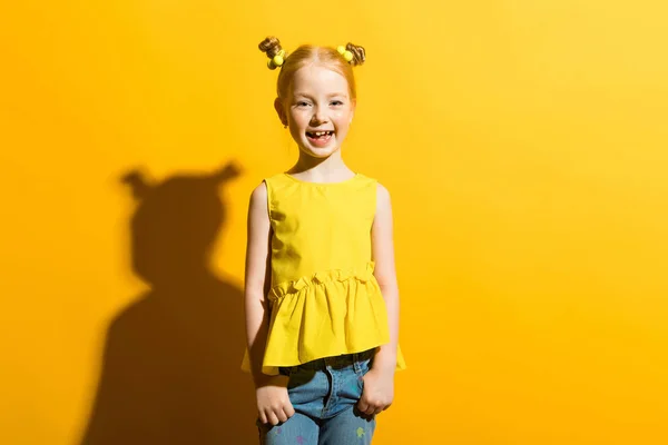 Ragazza con i capelli rossi su sfondo giallo. La ragazza sta ridendo . — Foto Stock